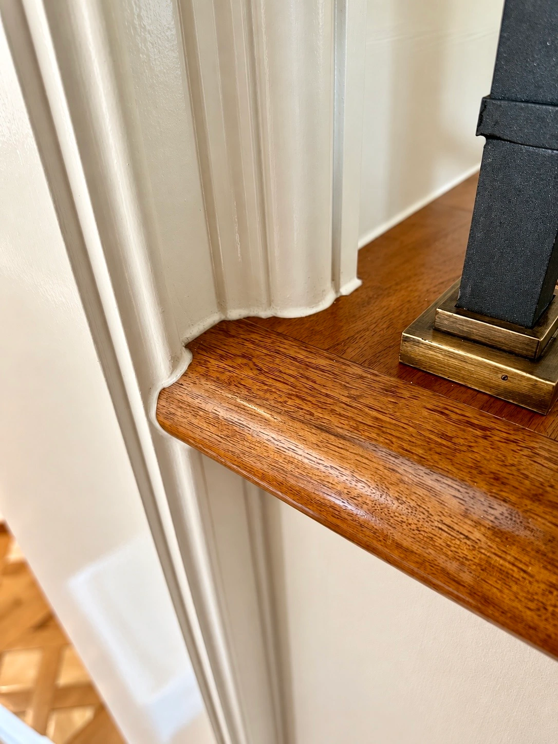 Detailed timber repair fitted around decorative trim beside a finished timber floor